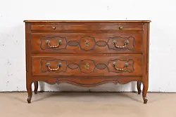 A gorgeous French Provincial Louis XV style commode, chest of drawers, or server. Carved walnut, with original brass...