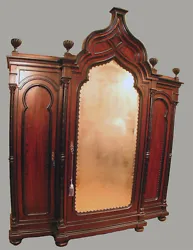 Circa 1875. Boldly detailed, with one large center door featuring an original beveled mirror and crowned with a...