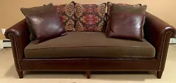 Brown leather sofa with fabric seat cushion having brown leather piping. Supplied as shown with leather and fabric...