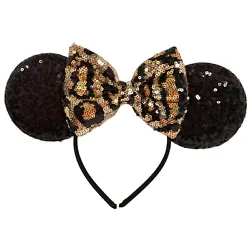 Black padded ears covered in black sequins with black animal print design bow covered with black and gold sequins.