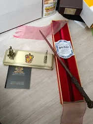 The Noble Collection Harry Potter Baguette Magique dHarry Potter + Socle Gryffondor en métal acheté a londre (boite...