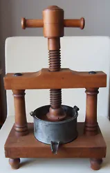 Ancien pressoir de table à vis en bois, récipient en métal.