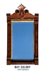 The mirror has painted ebony accents and shallow carvings on the corner blocks. The glass has a beveled edge and is in...