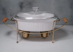 French White 3-qt. oval casserole has Pyrex lid and keep-warm serving stand that comes with two small candles. Rack has...