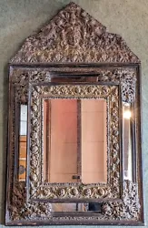 Superbe modèle de miroir à parcloses aux riches décors, beau travail de métal repoussé. Style haute époque, Louis...