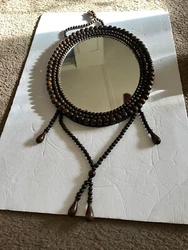 This beautiful beaded mirror has three rows of beads.  It has bead tassels.  It has a very small inperfection on the...