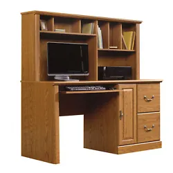 With its Carolina Oak finish, this desk will dazzle while youre getting the job done. Storage area behind raised panel...