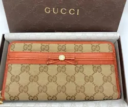 This auth used Gucci purse is a stylish and unique long wallet that features a brown canvas ribbon and the iconic GG...