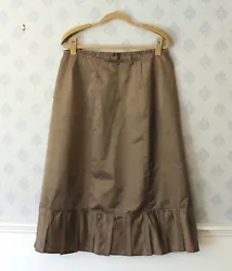Has a ruffled pleated hem. The waist line is flat across the flat and is gathered in the back. Im not sure if it was...