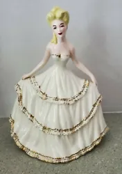 Holland Mold woman in a cream colored dress with gold trimming. She is 11