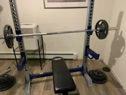 A Fitness Gear Pro Olympic Weight Bench, barbell, and set of weights. Barbell: 7 feet, 45 lbs, 700-lb capacity, two...