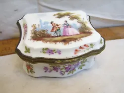 A nice little porcelain trinket box with a victorian or french provincial scene on it. Has what looks like a makers...