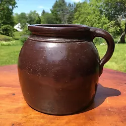 Nice early collectible stoneware bean pot in dark brown glaze. Graceful shape with nice incised detail below the rim...