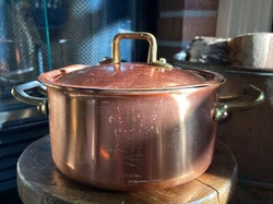 Small covered copper pot. COPRAL. Two brass handles with copper rivets. Pot stands 3 1/4” to top rim (without lid)....