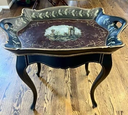 Table is covered in what appears to be leather (see close up photo). Excellent vintage condition.Tray doesn’t detach....