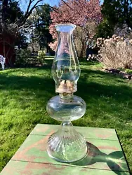 AN ANTIQUE PEDESTAL, SEWING, KEROSENE/OIL LAMP IN CLEAR GLASS. THE CLEAR GLASS FONT HAS A PLAIN DESIGN WITH THE BASE A...