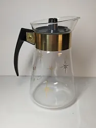 This vintage Corning coffee carafe features a beautiful atomic gold starburst pattern on heat proof glass, with a...