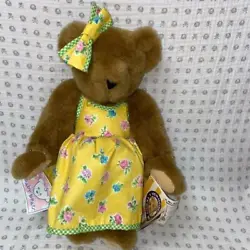 This adorable, rich brown bear features a cheery yellow bow and matching dress with contrast gingham. She is fully...