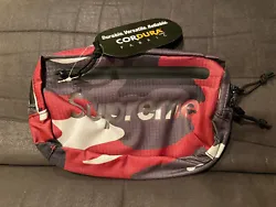 Stay stylish while carrying your essentials with this Supreme Waist Bag in Red Camo. This Belt Bag & Fanny Pack is made...