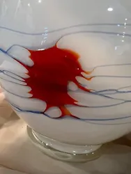 Really cool white art vase wrapped in blue glass swirls and featuring a mysterious red “eye” of glass. Glass is...