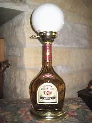 Gold glass with E & J Brandy label, it is 20 inches tall, has a Key to  turn on light  bulb  that is inside of a...