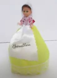 She has a lace scarf around her head and shoulders, red top and yellow bottom of the dress. This doll has blue eyes...