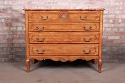 A gorgeous French Provincial Louis XV carved fruitwood four-drawer dresser or chest of drawers. Mid-20th Century. We do...