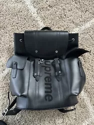 This is a stylish Louis Vuitton x Supreme LV Christopher backpack in black that is perfect for any fashion-forward man....