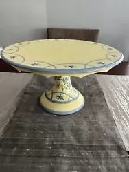 This item is a pre owned Capriware ceramic hand painted in China Cake plate. The color is yellow with blue and purple...