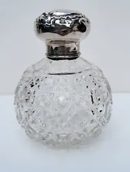 Circa 1900 perfume bottle with crystal applicator/stopper and Hallmarked silver top with detailed design.  There are...