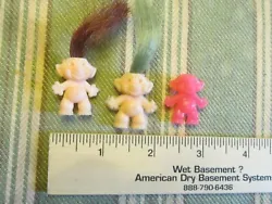 You will receive the three troll babies pictured. The pink one never had hair. There is NOT any staple holes at the top.