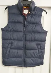 This Old Navy Mens navy blue puffer vest is a stylish addition to any casual outfit. With a solid pattern and a relaxed...
