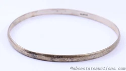 This sterling silver bangle bracelet exudes simple elegance with its understated design. Its stamped with 