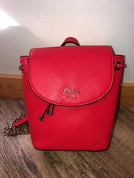 Flap and snap closure with drawstring too. The inside features a zipper pocket and a drop pocket. Actually very roomy...