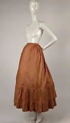 FASHIONED OF A BUTTERSCOTCH COLORED POLISHED COTTON WITH THE BOTTOM IN A FLOUNCED RUFFLE. DATING TO THE VICTORIAN 19TH...