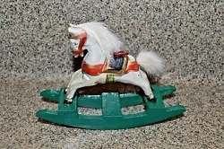 White horses with red bridles and gold trim on green wooden rocking bases. Faux hair for mane and tail. Also great...