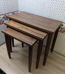 Set of 3 nesting tables, faux wood formica/vinyl tops and wooden screw-on legs. Nice with some light wear and tear...